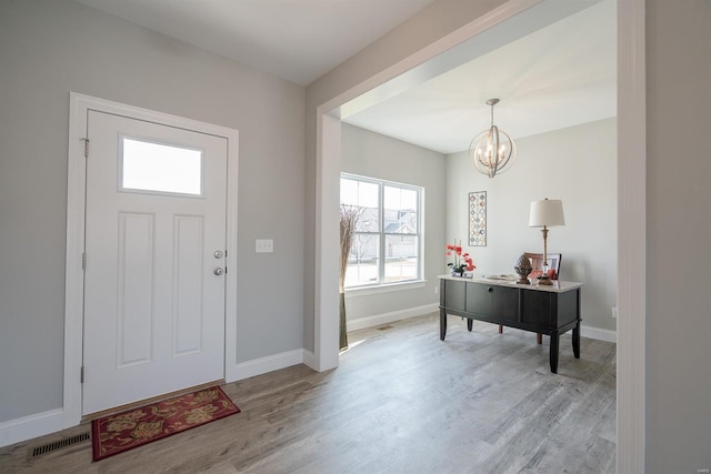 entryway featuring light wood-type flooring and a chandelier