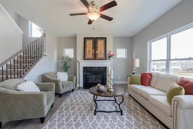 living room with ceiling fan, wood-type flooring, and a healthy amount of sunlight