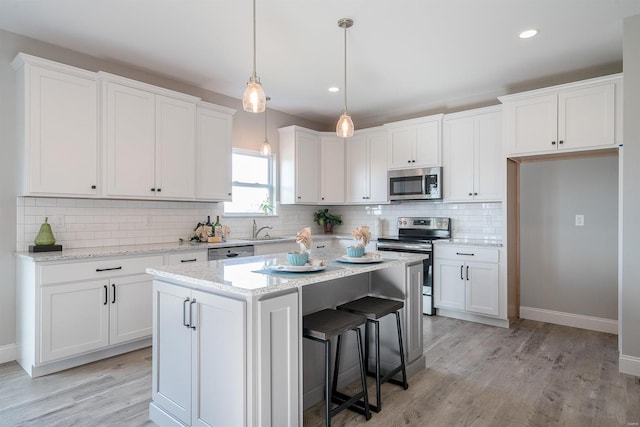 kitchen featuring light hardwood / wood-style floors, backsplash, stainless steel appliances, and white cabinets