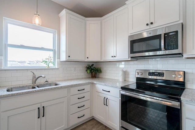 kitchen featuring sink, decorative backsplash, white cabinets, and stainless steel appliances