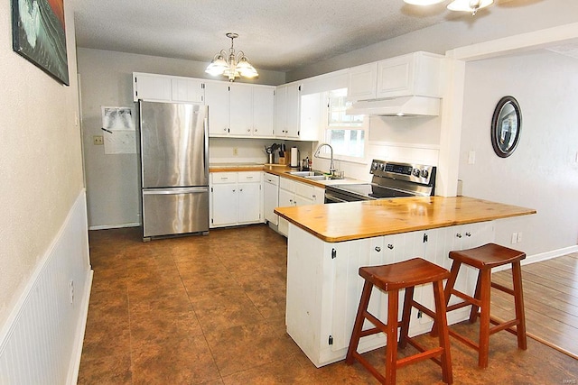 kitchen with custom range hood, appliances with stainless steel finishes, a kitchen bar, white cabinetry, and kitchen peninsula