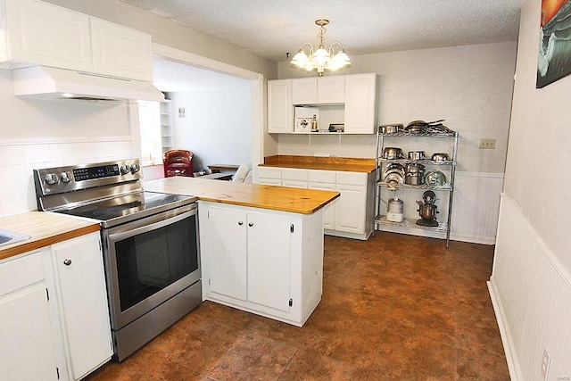 kitchen featuring custom exhaust hood, white cabinetry, kitchen peninsula, butcher block countertops, and stainless steel range with electric cooktop