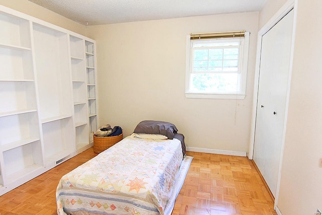 bedroom with a textured ceiling and light parquet flooring