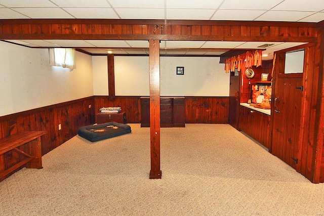 basement with a drop ceiling and carpet floors