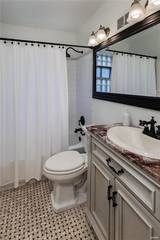 full bathroom featuring shower / bath combo, vanity, tile patterned flooring, and toilet