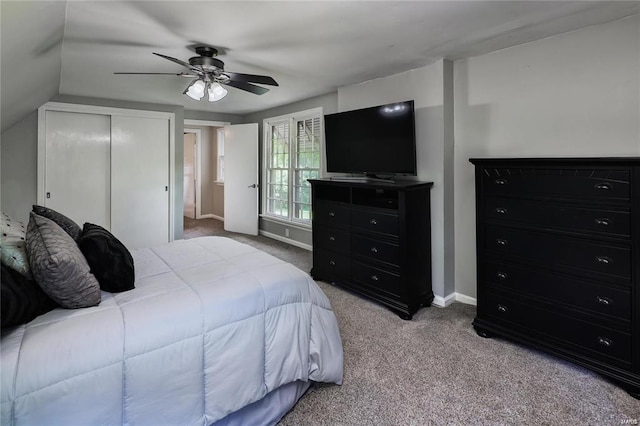 carpeted bedroom featuring ceiling fan, a closet, and vaulted ceiling