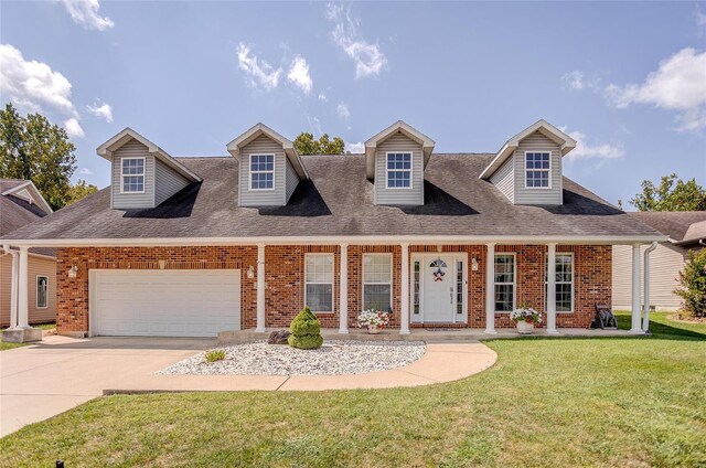 cape cod house featuring a garage and a front lawn