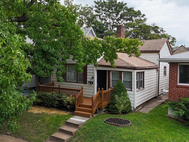 view of front of house featuring a deck and a front yard