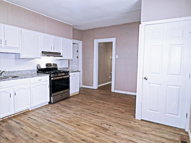 kitchen featuring light wood-type flooring, gas range, sink, and white cabinets