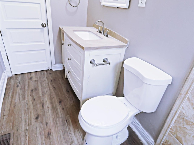 bathroom with hardwood / wood-style floors, toilet, and vanity