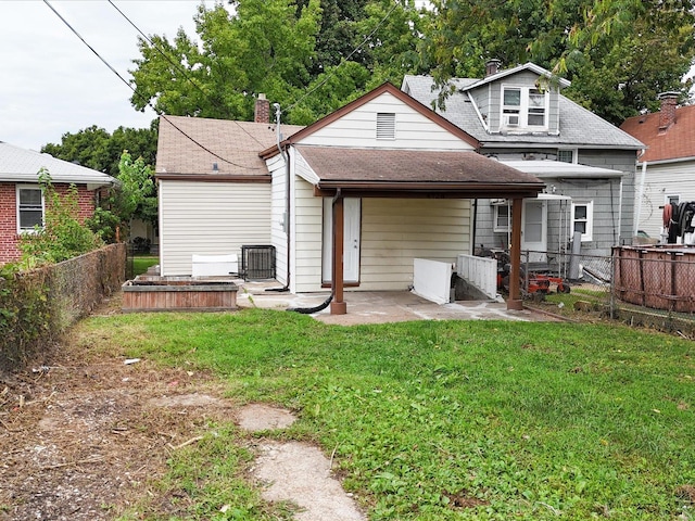 rear view of property with a patio and a yard