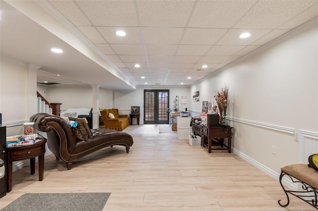 sitting room featuring french doors, light wood finished floors, recessed lighting, ornamental molding, and baseboards