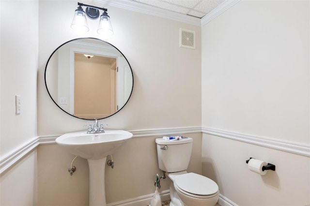 half bath with a paneled ceiling, baseboards, visible vents, and toilet