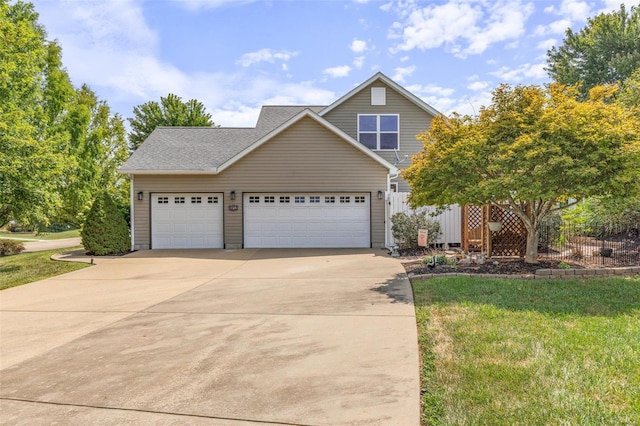 traditional-style house featuring a shingled roof, a front lawn, and concrete driveway