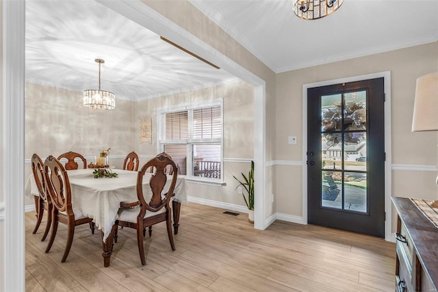 dining area featuring crown molding, light wood-style flooring, baseboards, and an inviting chandelier