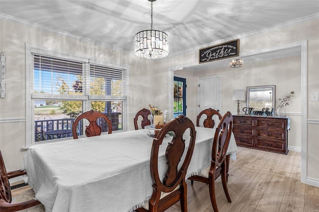 dining room featuring a chandelier, crown molding, baseboards, and light wood-style floors