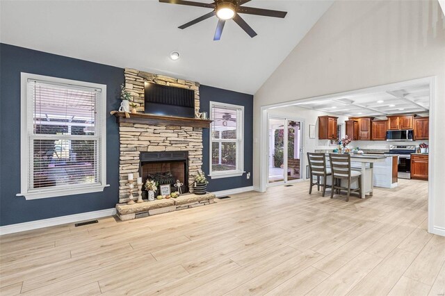 living room with light wood-type flooring, a fireplace, visible vents, and baseboards