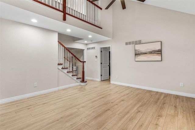 unfurnished living room featuring visible vents, light wood-style flooring, and baseboards