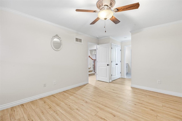 spare room featuring baseboards, visible vents, stairway, and light wood finished floors