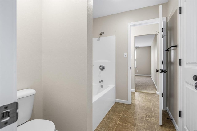 full bathroom featuring toilet, washtub / shower combination, and baseboards