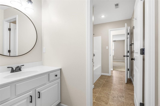 bathroom featuring visible vents, shower / bathing tub combination, vanity, and baseboards