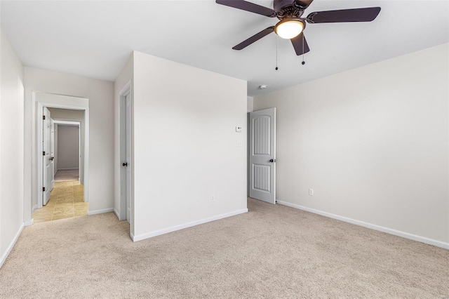 unfurnished bedroom featuring baseboards, a ceiling fan, and light colored carpet