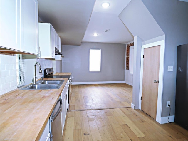 kitchen featuring appliances with stainless steel finishes, light hardwood / wood-style floors, tasteful backsplash, sink, and white cabinets