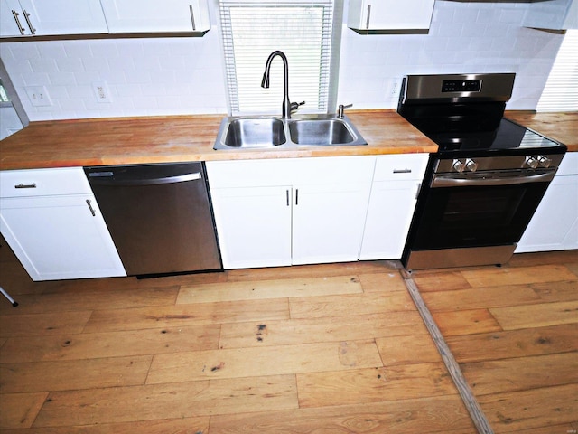 kitchen with light hardwood / wood-style floors, appliances with stainless steel finishes, sink, and white cabinets