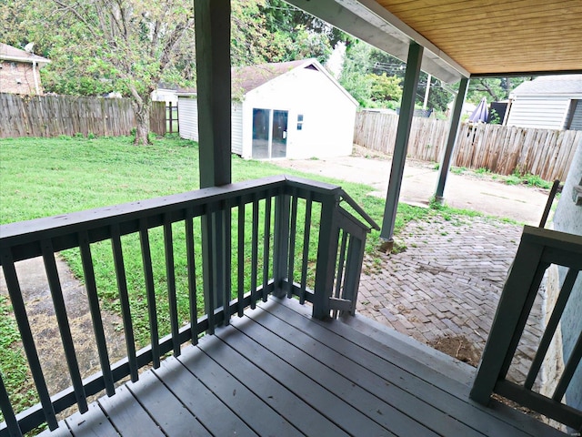 wooden deck featuring an outdoor structure and a yard