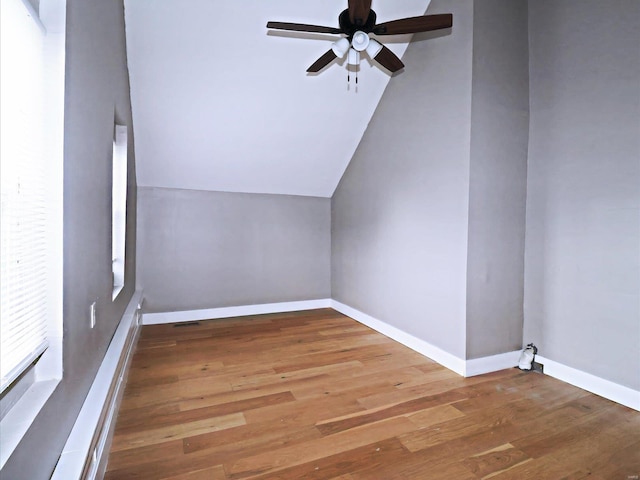 additional living space with hardwood / wood-style floors, vaulted ceiling, and ceiling fan