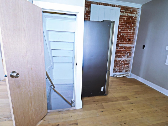 interior details with hardwood / wood-style floors and fridge