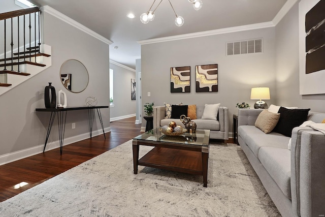 living room with crown molding, wood-type flooring, and a chandelier