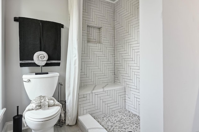 bathroom featuring a shower with shower curtain and toilet