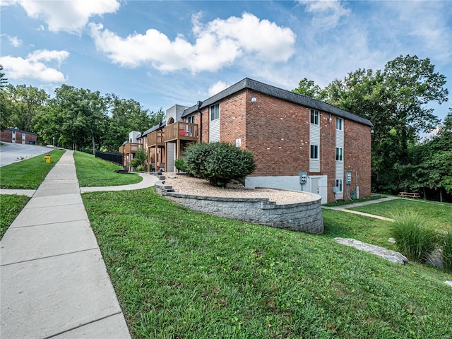 view of side of home with brick siding and a lawn