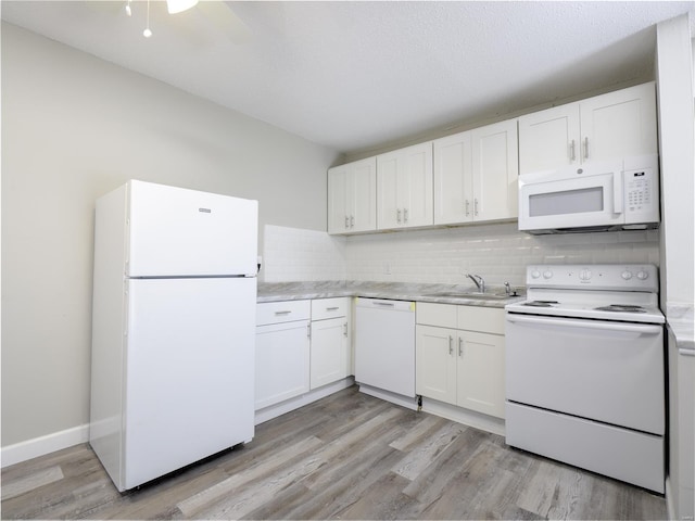 kitchen featuring white cabinetry, backsplash, light wood-type flooring, white appliances, and sink