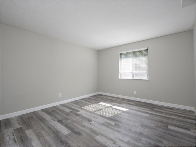 empty room with baseboards and wood finished floors