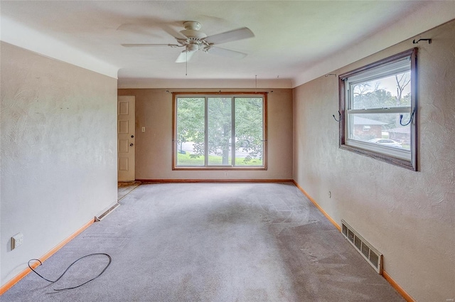 carpeted spare room with ceiling fan