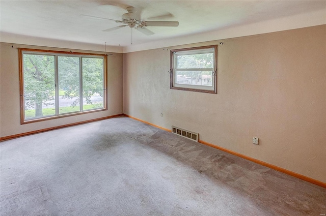 carpeted empty room with ceiling fan and a healthy amount of sunlight