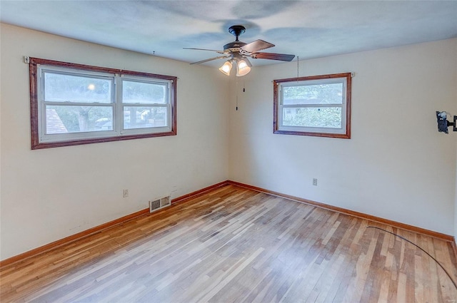 empty room with light hardwood / wood-style flooring, ceiling fan, and plenty of natural light