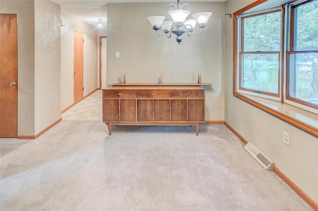 dining area with a chandelier and light colored carpet