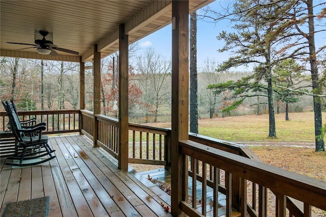 wooden deck with ceiling fan and a lawn