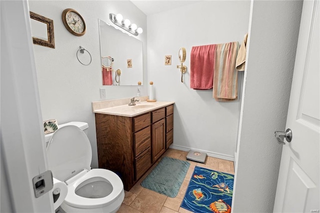 bathroom with toilet, tile patterned floors, baseboards, and vanity