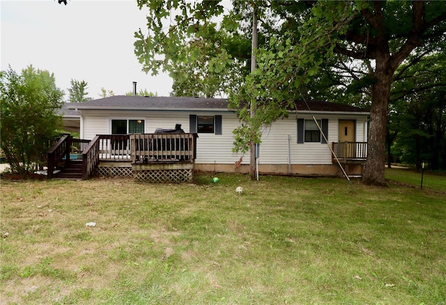 back of property with a wooden deck and a yard