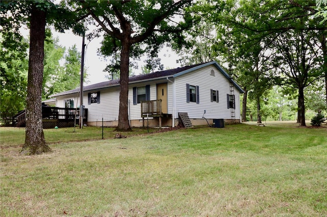 rear view of property with a lawn and a wooden deck