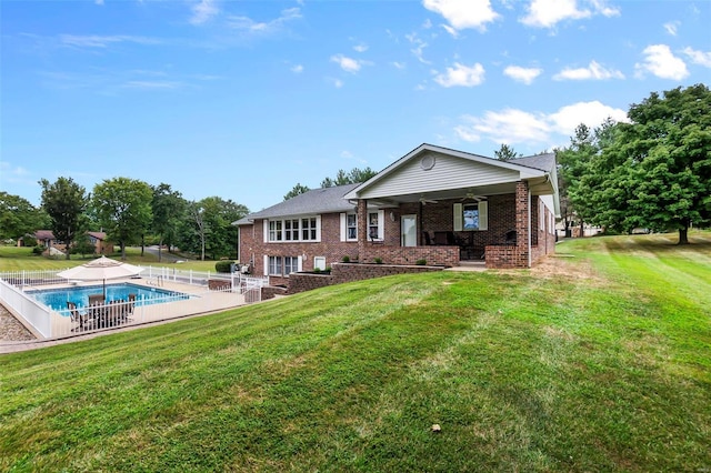 rear view of property with ceiling fan, a patio, and a lawn