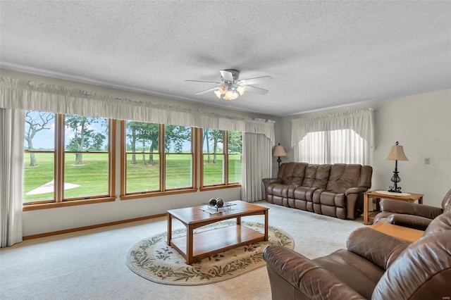 living room featuring ceiling fan, a textured ceiling, and light carpet