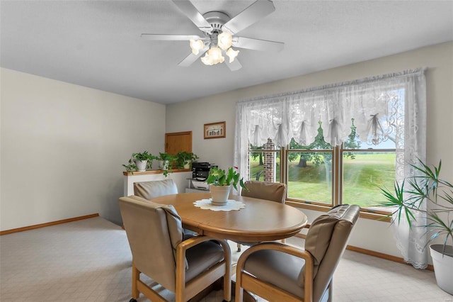 dining space featuring ceiling fan and light colored carpet