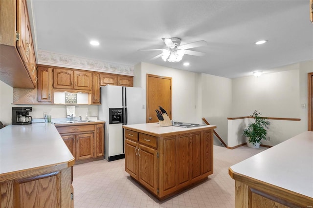 kitchen featuring white fridge with ice dispenser, light tile patterned floors, a center island, ceiling fan, and sink