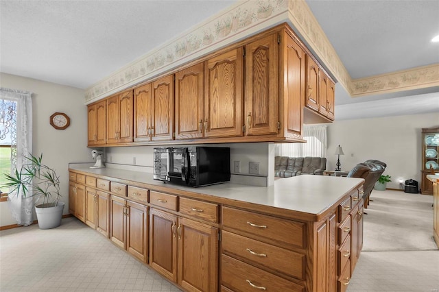 kitchen featuring kitchen peninsula and light colored carpet