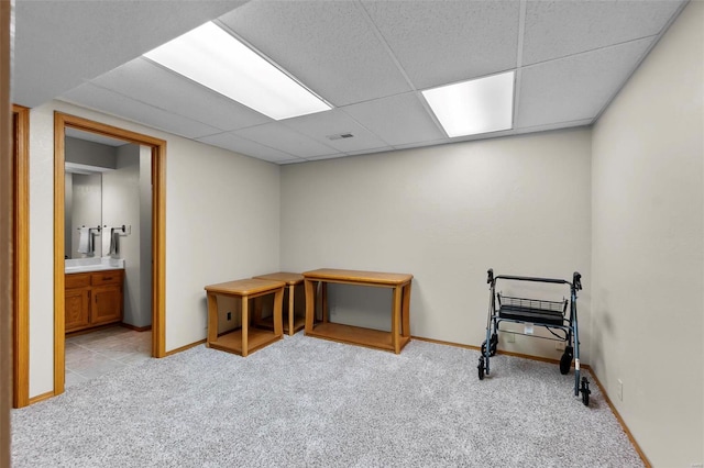 interior space featuring a drop ceiling and light carpet